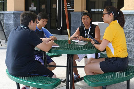 A group of students sitting around an outdoor table